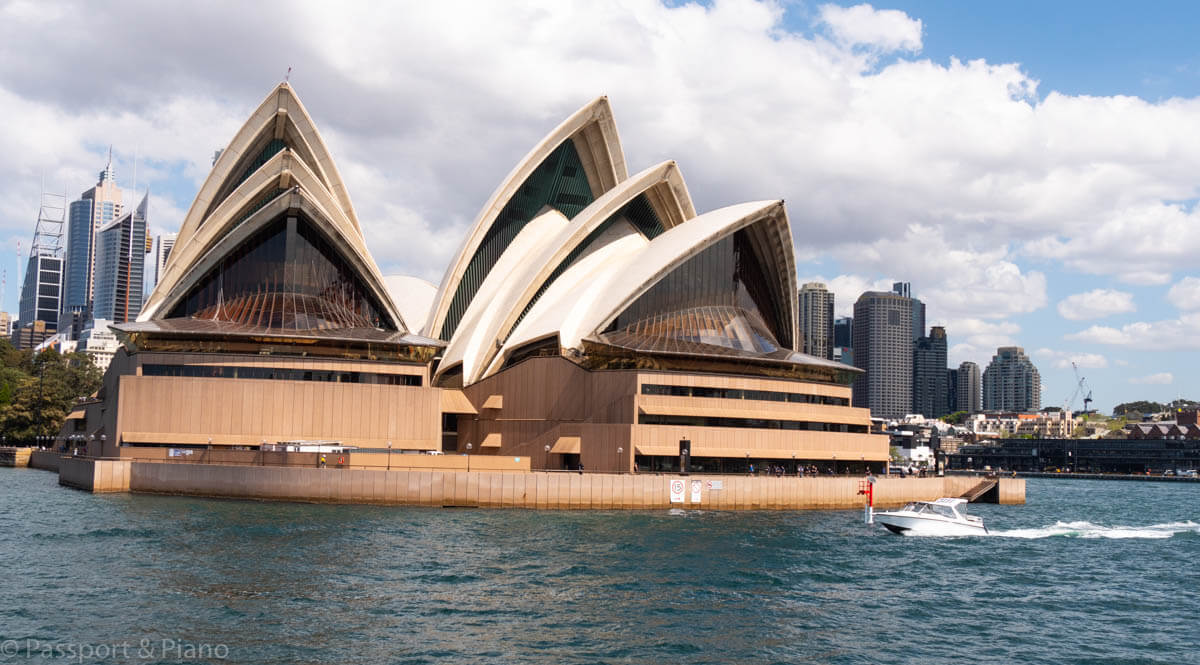An image of the front view of Sydney Opera House as the ferry sails past.