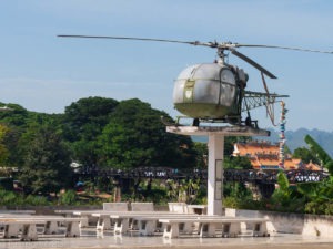 Image of the helicopter with the bridge over the River Kwai in the background at Jeath museum