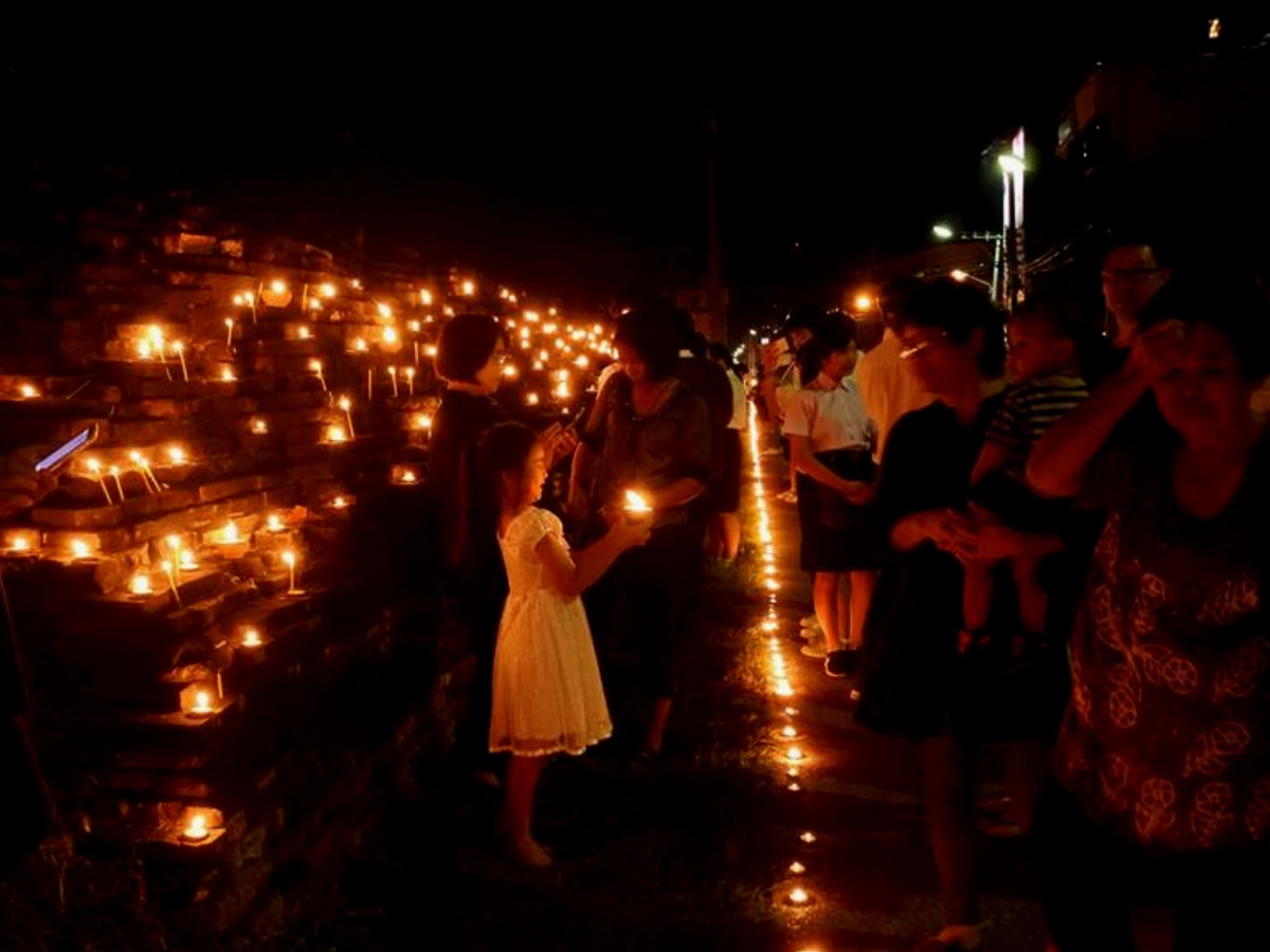 An image of a girl with a candle surrounded by flickering lights at the Thai Festival of Loi Krathong