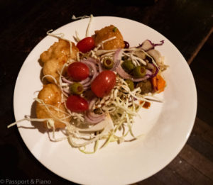 An image of a plate of food which includes salad and cabbage fritters