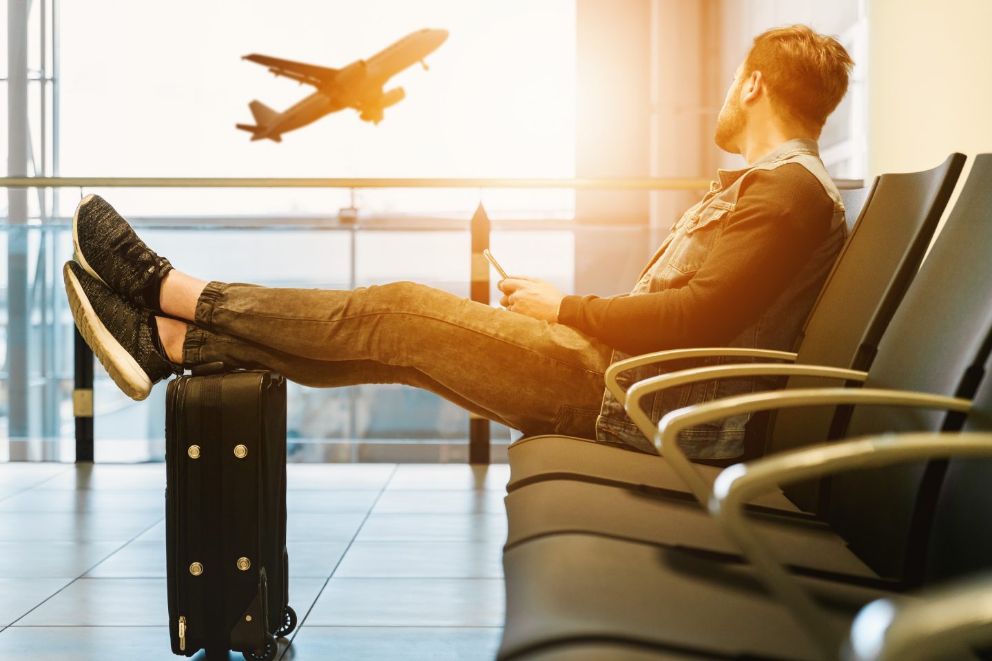 An image of a man with his suitcase and an aeroplane
