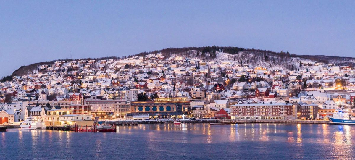An image of Tromso Norway with the city lights and waterfront.
