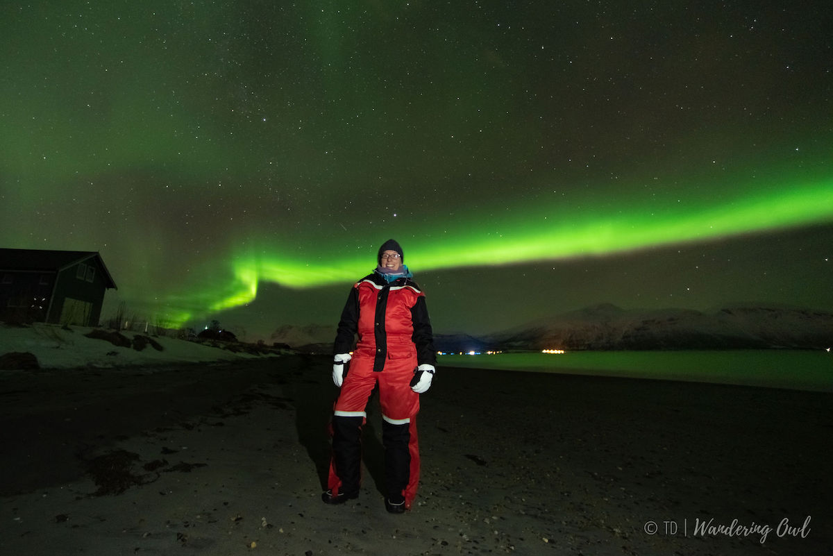 An image of me in a red thermal suit with a green aurora in the background