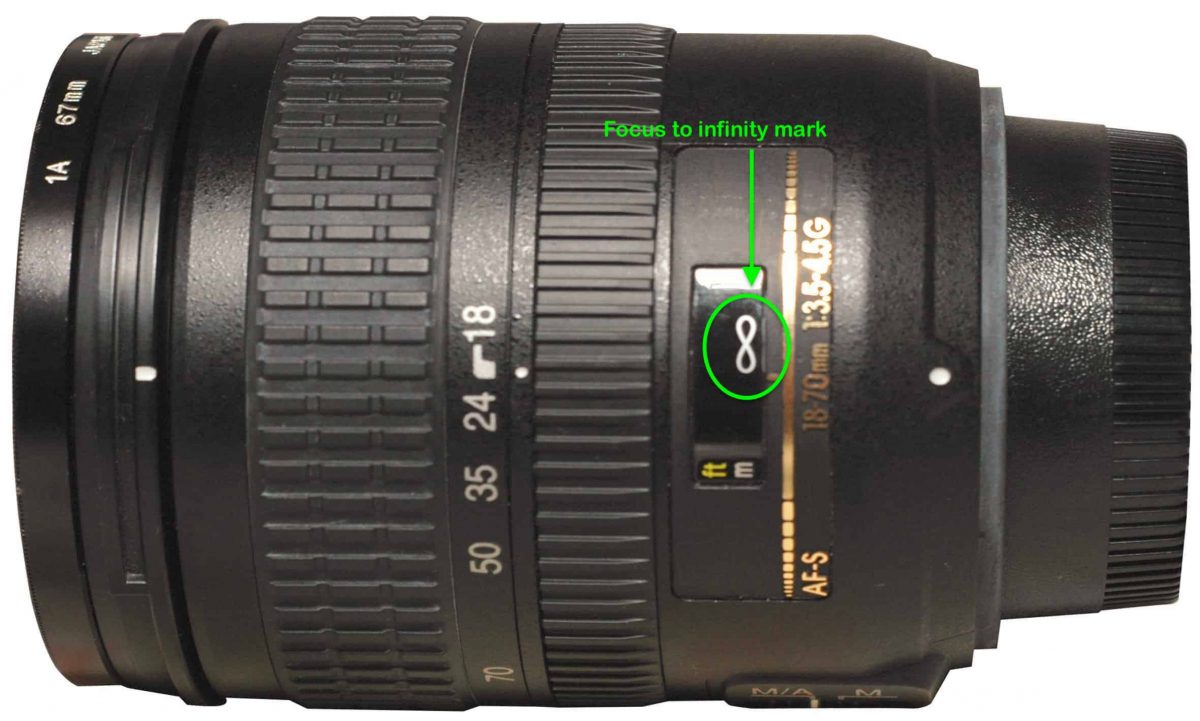 An image showing a camera lens with the focus to infinity mark on it